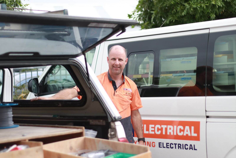 b and m electrician standing behind van with open rear door